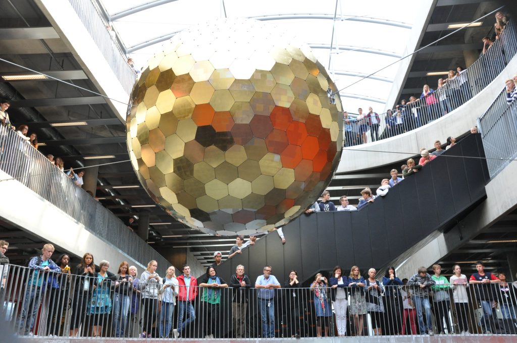 The team of autogena projects standing behind the completed gilded orb.